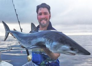 Marcus Pearson with one of the sharks, a small mako taken in 50 metres of water off the Black Rock outfall (Picture Kevin McLoughlin).