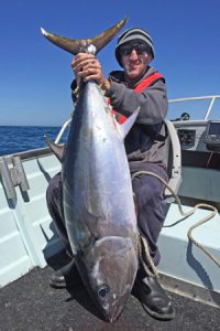 Jeremy McLoughlin with the tuna he caught offshore from the Black Rock outfall (Picture: Kevin McLoughlin).