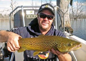 Clint Hotchin with a brown trout he caught from Lake Toolondo recently (Picture: Victorian Inland Charters).   