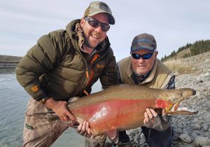 Over the rainbow: Fishing guide Graham Edridge and Local angler Darryl Luttrel with Darryl’s 19 kg (42 lb) rainbow trout from the Ohau canal on New Zealand’s South Island (Picture: Tom Kulczynski).   