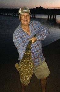 Leon Leonardo shows off one of the flathead he’s been catching from Merimbula Lake in southern NSW lately (Picture: Courtesy of Dave Matthews).